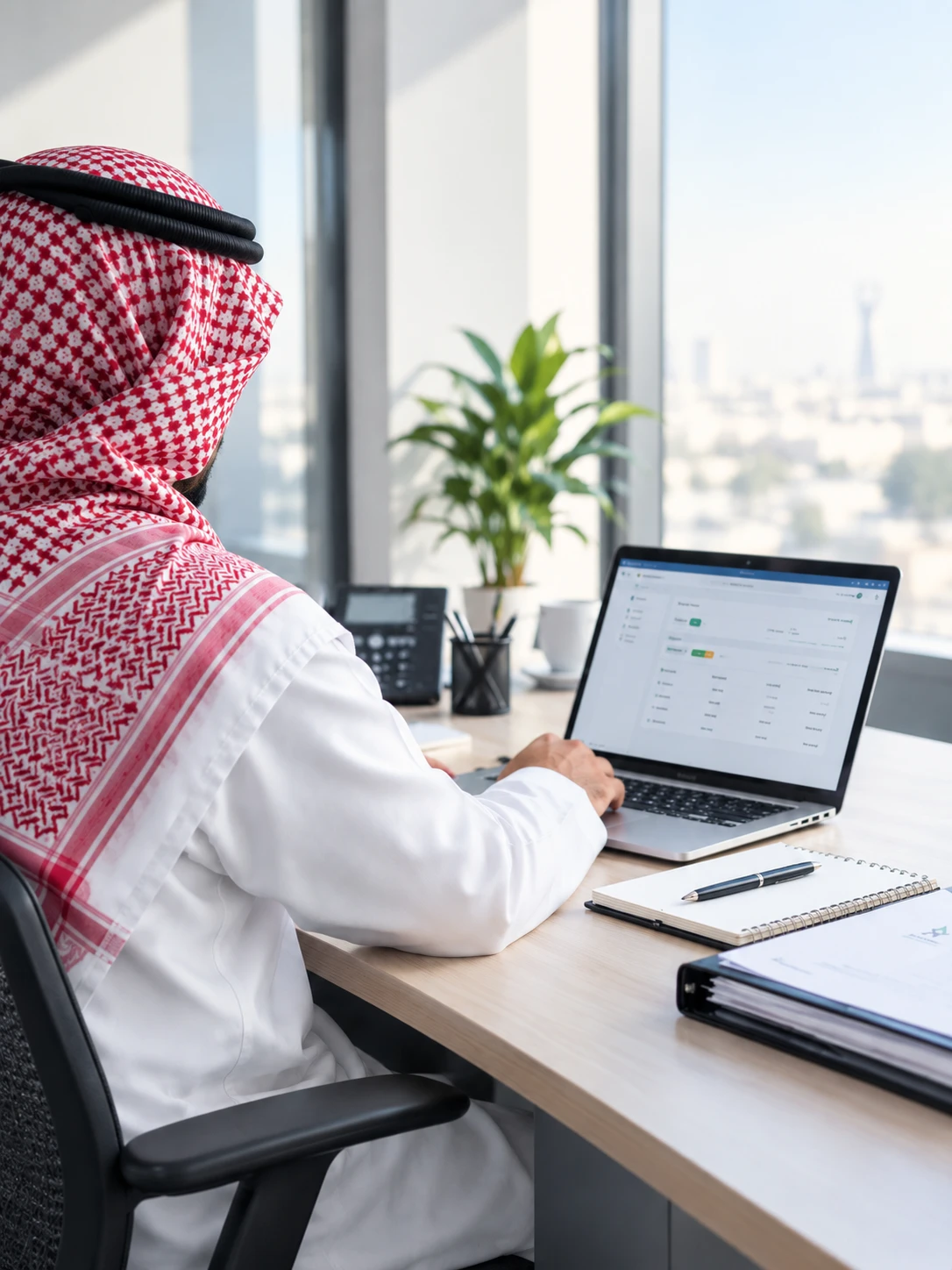 موظف في جمعية يعمل على لابتوب في مكتبه